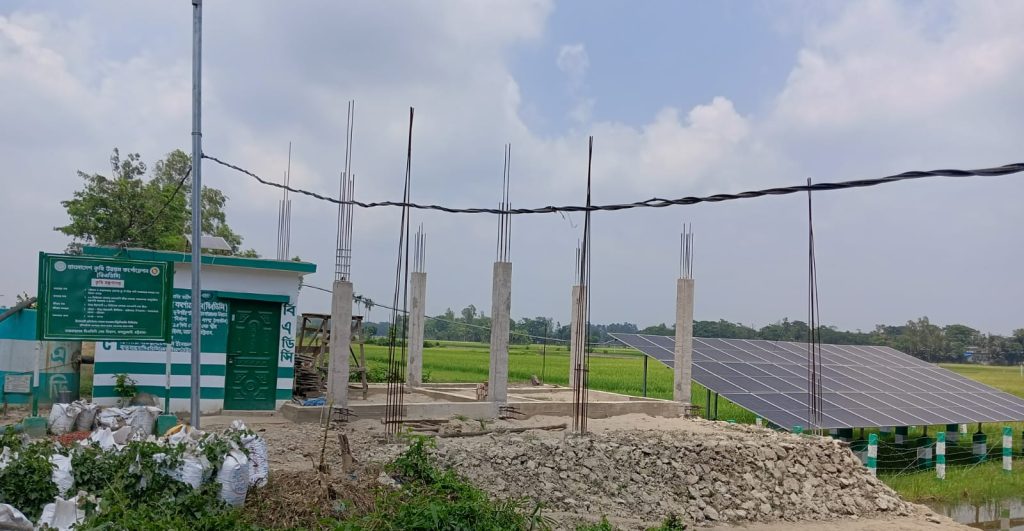 নির্মাণাধীন দ্বিতীয় সোলার সেচ স্কিম। বাঁ দিকে বিএডিসির তথ্য বোর্ডসহ কার্যালয় ভবন, পাশে ইতোমধ্যে স্থাপিত সোলার প্যানেল এবং নির্মাণাধীন স্থাপনা দেখা যাচ্ছে। এই প্রকল্পটি চালু হলে আরও ১০ হেক্টর জমি সোলার সেচের আওতায় আসবে।